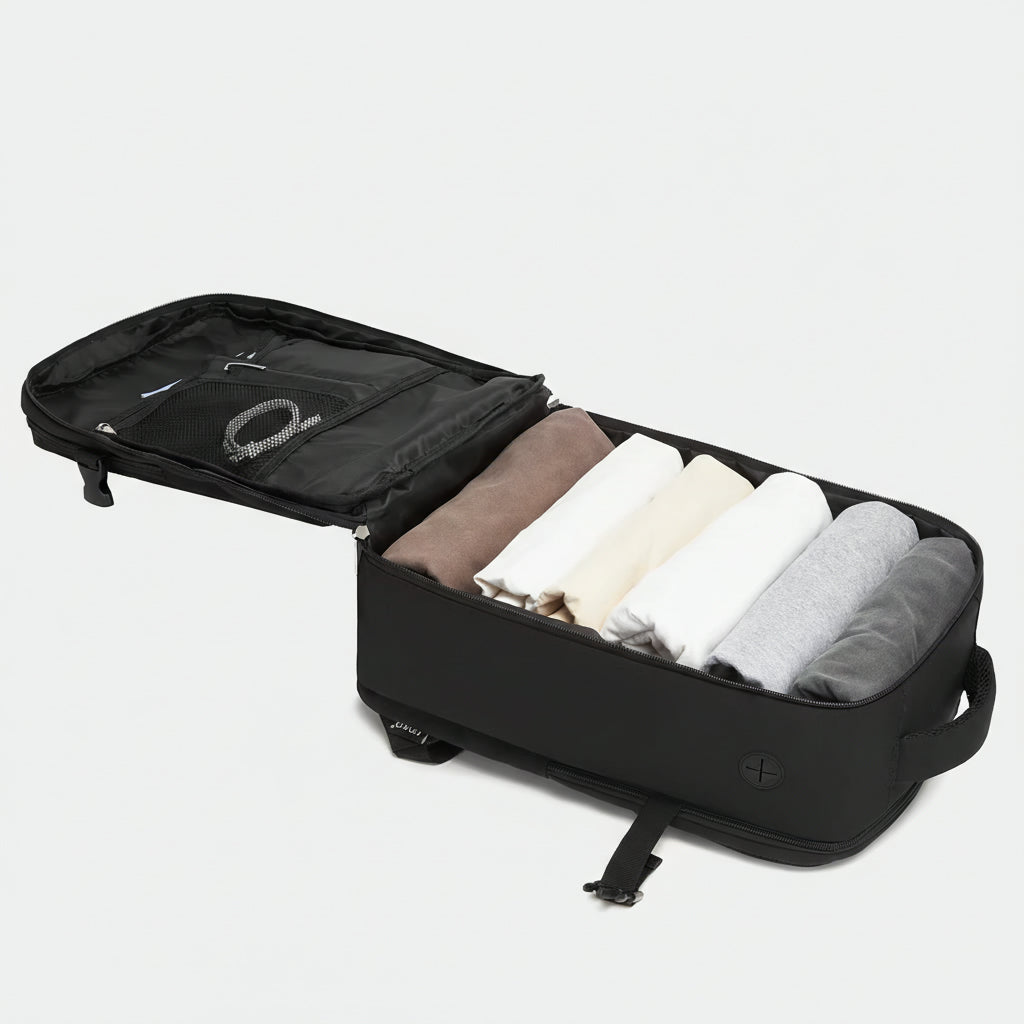 Sac à dos cabine noir ouvert à plat révélant des vêtements roulés rangés et une poche organisateur avec filet Image