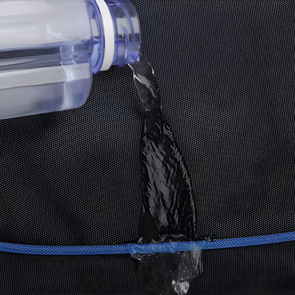 Gros plan sur le tissu imperméable d'un sac à dos noir avec filet de fermeture bleue repoussant l'eau versée Image