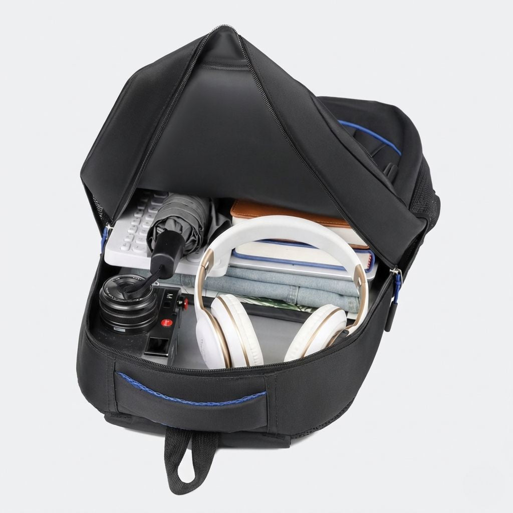 Compartiment principal ouvert du sac à dos vu du dessus avec casque audio, caméra et tablette à l'intérieur