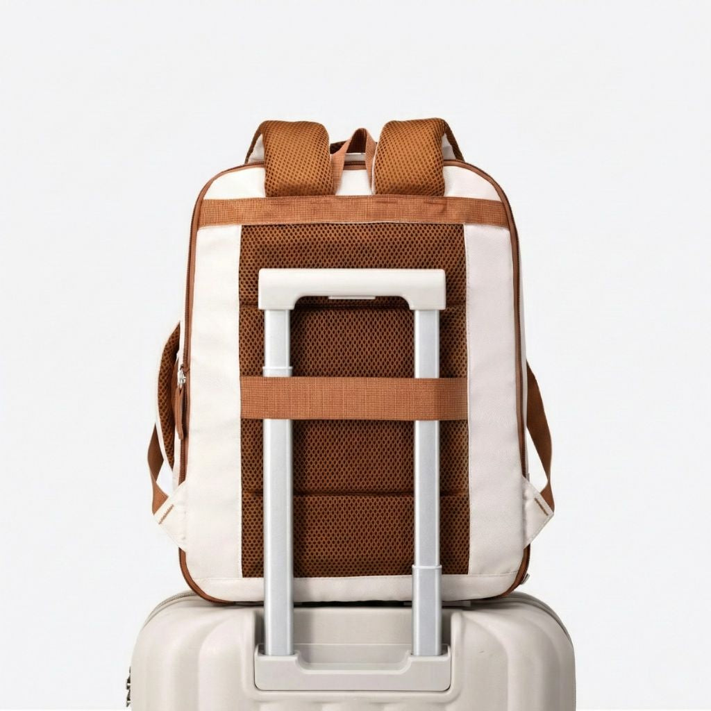 Vue de dos d'un sac à dos cabine femme beige posé sur la poignée d'une valise via sa sangle trolley Image