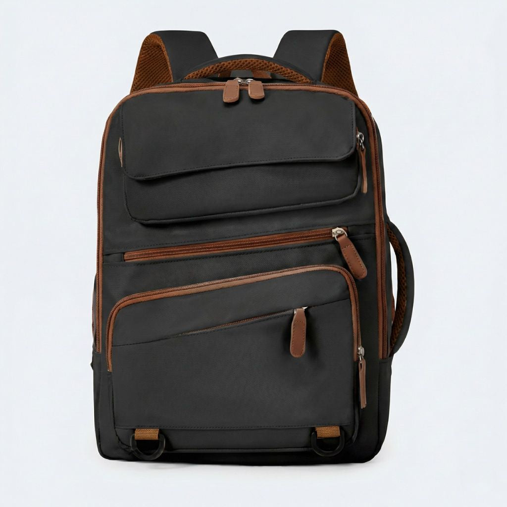 Sac à dos de voyage noir avec accents et tirettes caramel, poche frontale à rabat, vue de face