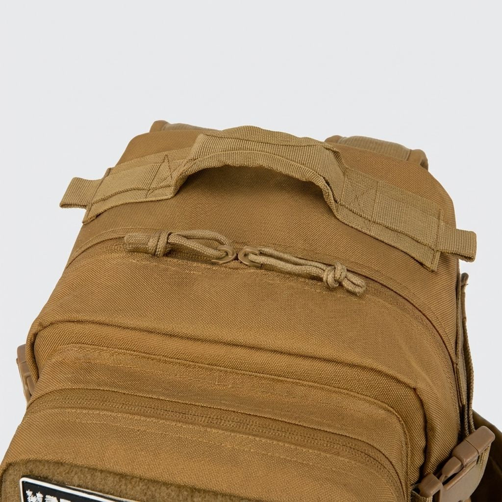 Gros plan sur le haut du sac à dos tactique marron coyote montrant la poignée et le système de cordon paracord