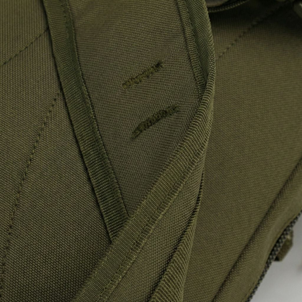 Gros plan sur le dos du sac à dos vert olive avec les coutures renforcées du dosseret matelassé en losanges