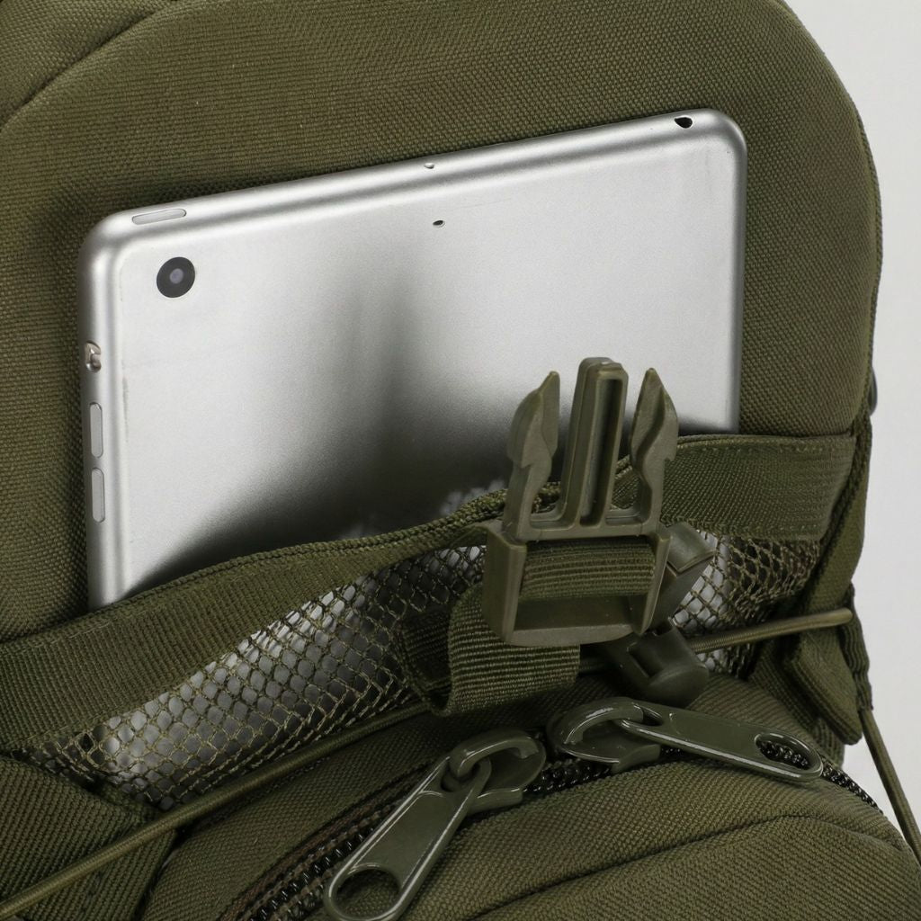 Gros plan sur la poche dorsale d'un sac militaire vert avec tablette glissée et support de fixation MOLLE intégré Image
