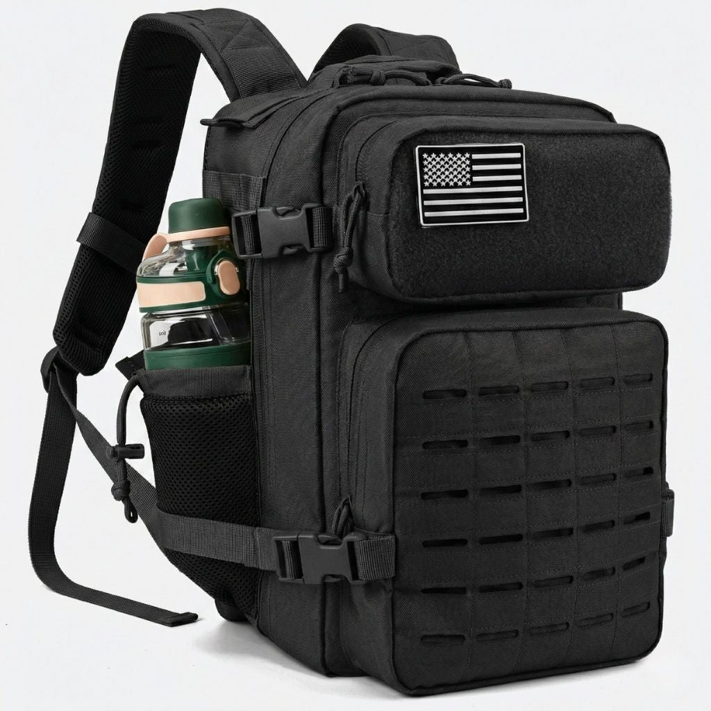 Sac à dos tactique noir vue 3/4 gauche, grille MOLLE laser-cut, patch drapeau américain et porte-gourde filet
