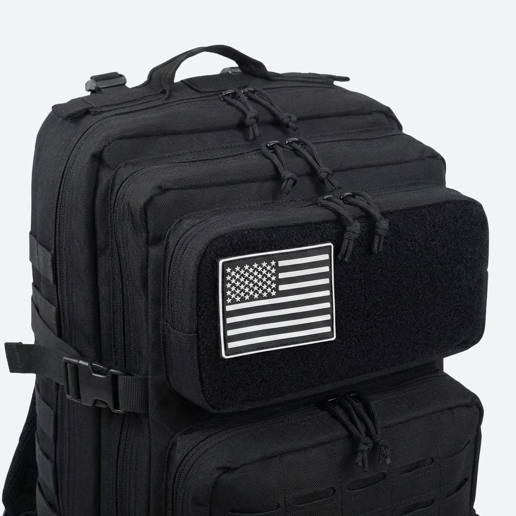 Gros plan du patch drapeau américain noir et blanc sur la poche velcro supérieure du sac à dos tactique