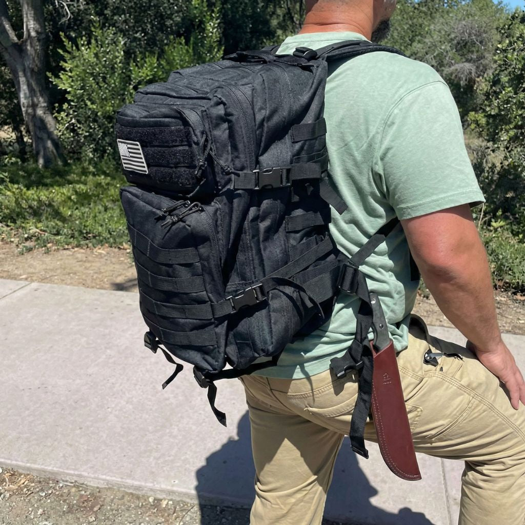 Lifestyle : homme portant le sac à dos militaire 45L noir en extérieur naturel, vue de dos en zone boisée