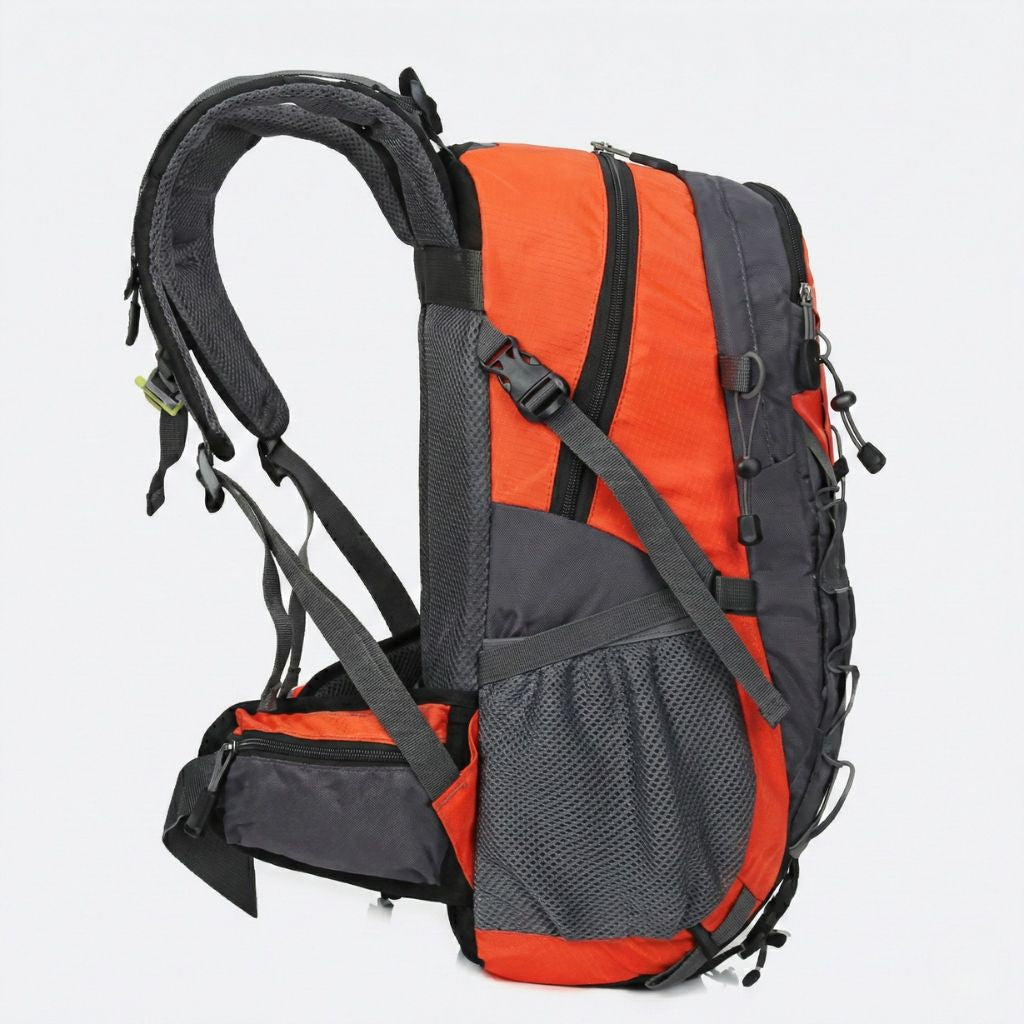 Vue latérale du sac à dos de randonnée orange 40L, bretelles ergonomiques et poche filet latérale visible