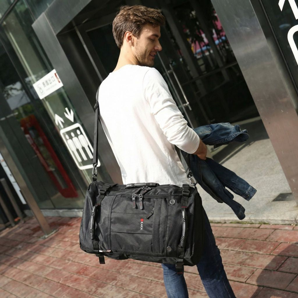 Homme portant en bandoulière un grand sac à dos de voyage noir multipoches à 3 modes de portage Image