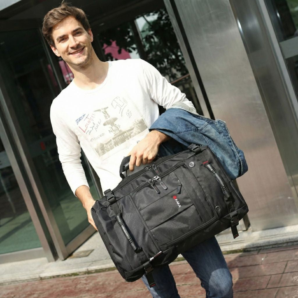 Homme souriant tenant le grand sac de voyage noir à la main en mode duffle bag devant des vitrines en ville
