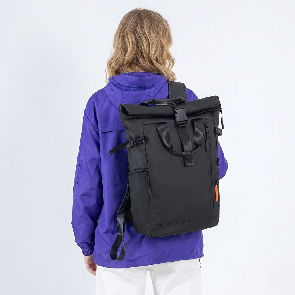 Sac à dos voyage roll-top noir vu de dos sur une personne, bretelles ajustées, veste violette et languette orange