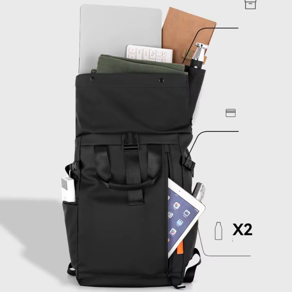 Sac à dos roll-top noir ouvert révélant sa capacité, ordinateur portable, tablette, carnets et accessoires rangés