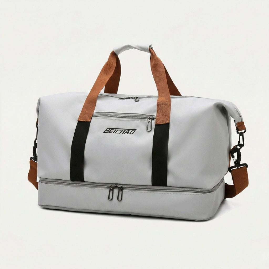Sac de sport gris clair avec poignées et bandoulière caramel, compartiment chaussures séparé zippé, vue 3/4