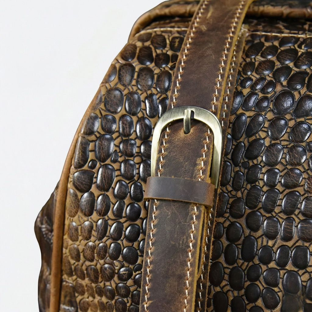 Boucle de sangle en laiton du sac de voyage cuir croco brun, coutures contrastantes fauve visibles Image