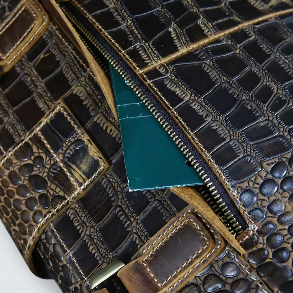 Poche du dessus ouverte du sac de voyage cuir croco, document glissé dans la poche, fermeture éclair laiton