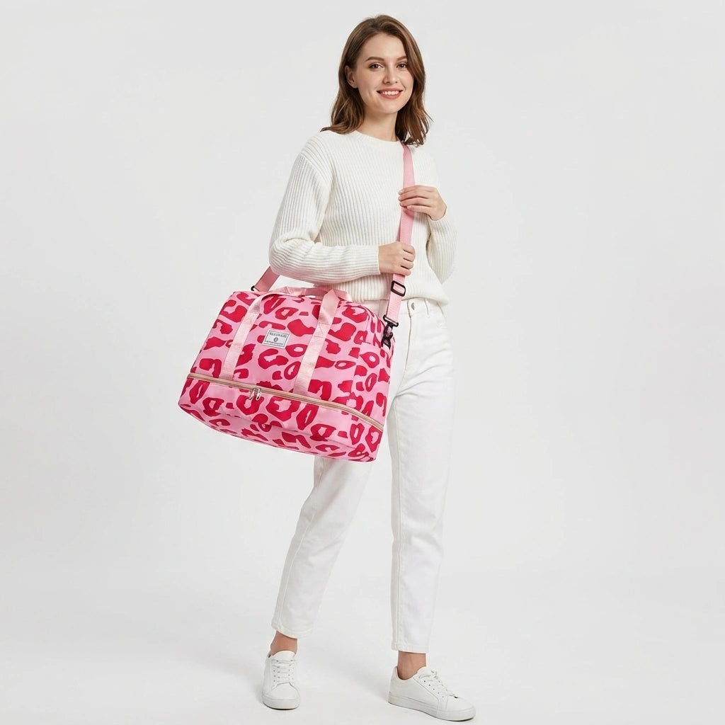 Sac de voyage femme rose léopard fuchsia porté en bandoulière sur l'épaule, compartiment chaussures zippé visible