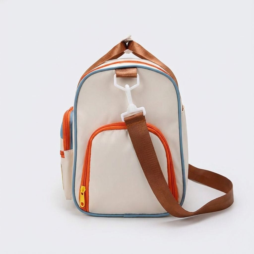 Sac de voyage femme beige multicolore avec compartiment chaussures et bandoulière marron, poches zippées visibles de face, vue de côté sur fond uni