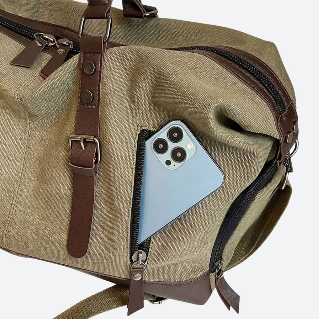 Sac de voyage en toile kaki avec poche latérale zippée et détails en cuir marron en gros plan Image