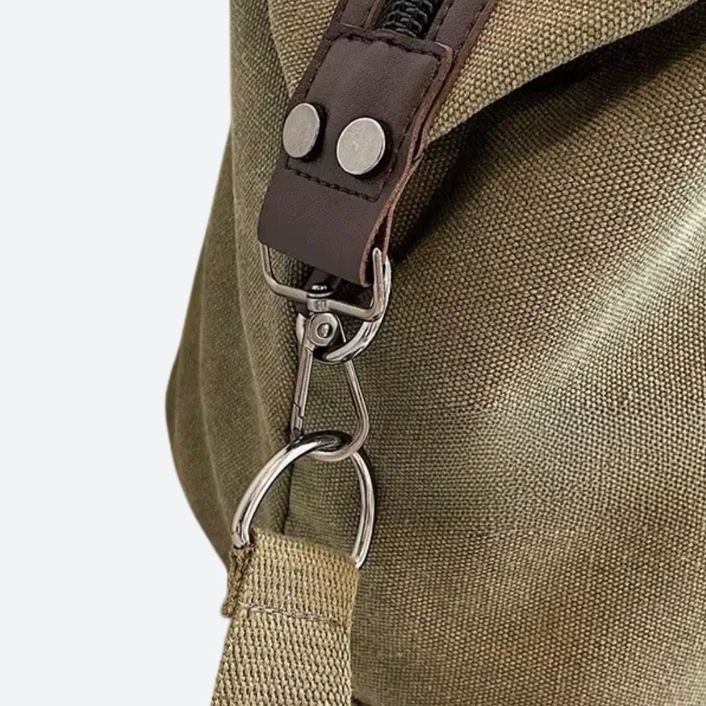 Sac de voyage en toile kaki avec attache bandoulière en métal et détails en cuir marron en gros plan