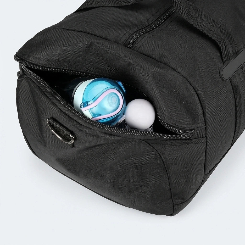 Poche latérale d'un sac de voyage noir ouverte avec une gourde bleue et une balle, compartiment humide