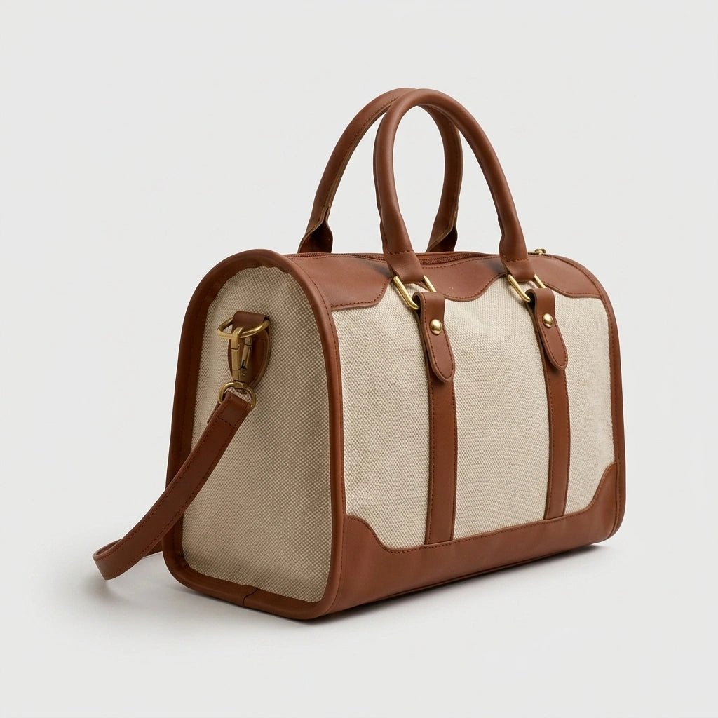 Sac de voyage style vintage en toile beige et cuir cognac, vue 3/4 avec double poignée et bandoulière dorée