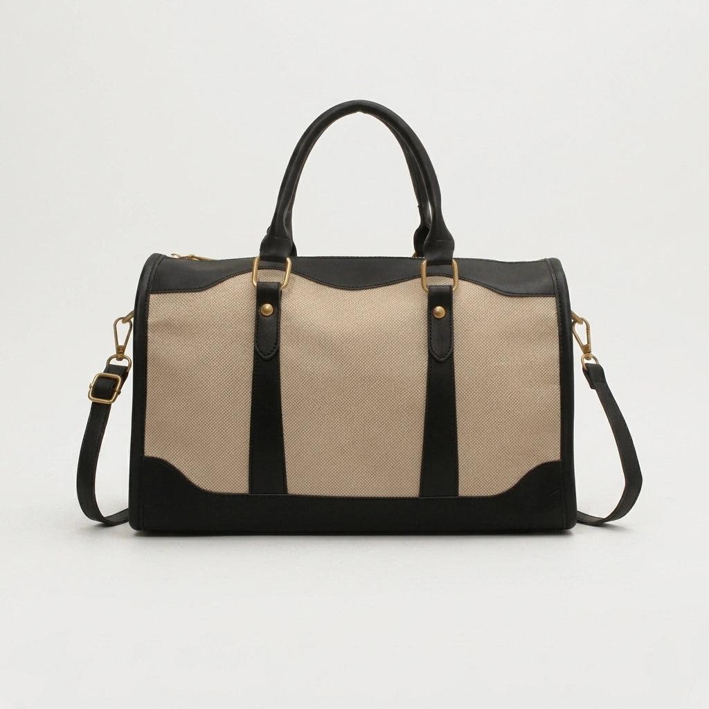 Sac de voyage vintage noir petit format, vue 3/4 sur fond gris, avec bandoulière noire et quincaillerie dorée