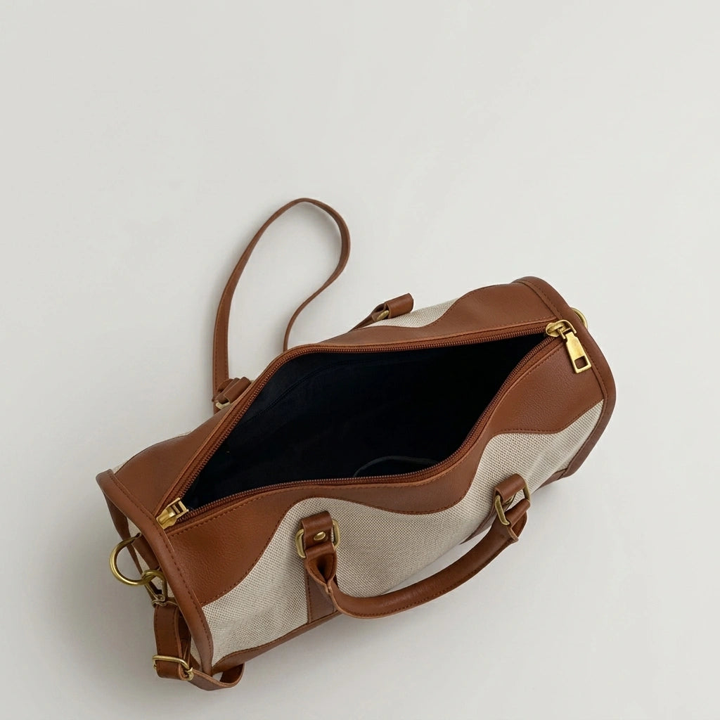 Sac de voyage vintage camel vu de dessus ouvert, révélant l'intérieur noir et les fermetures dorées