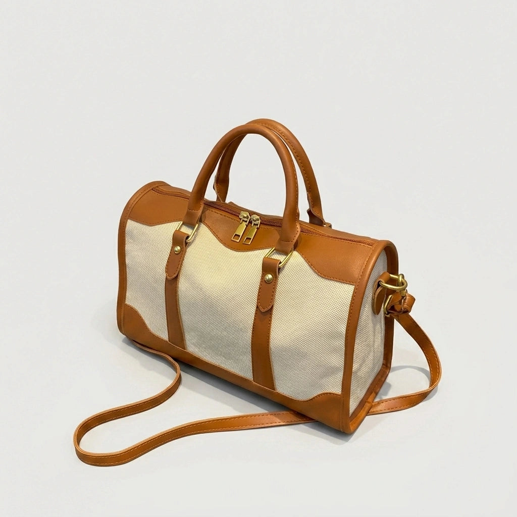 Sac de voyage vintage camel petit format posé au sol, vue 3/4 avec ombre naturelle et bandoulière cognac