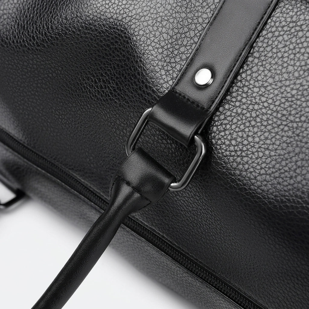 Gros plan sur la fixation métal gunmetal de bandoulière du sac de voyage homme en simili cuir noir Image