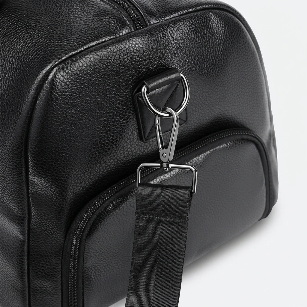 Détail du mousqueton et clip de bandoulière en métal gunmetal d'un sac de voyage noir imperméable