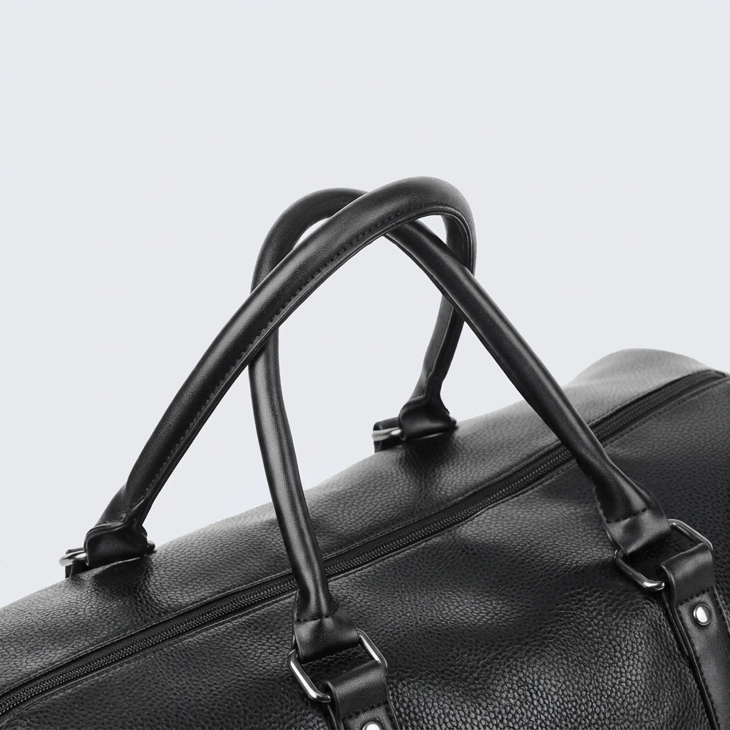 Détail des doubles poignées arrondies en simili cuir noir d'un sac de voyage homme étanche et résistant Image