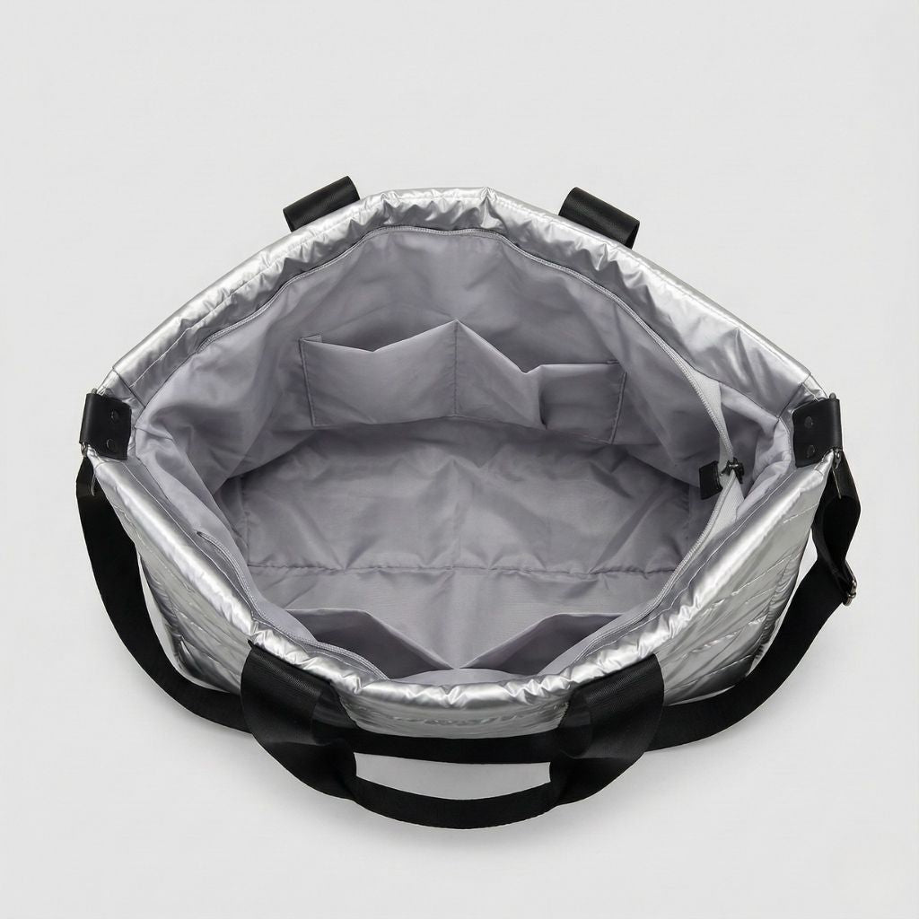 Intérieur d’un sac de voyage matelassé grand format souple gris avec poches internes et anses noires pour bandoulière amovible