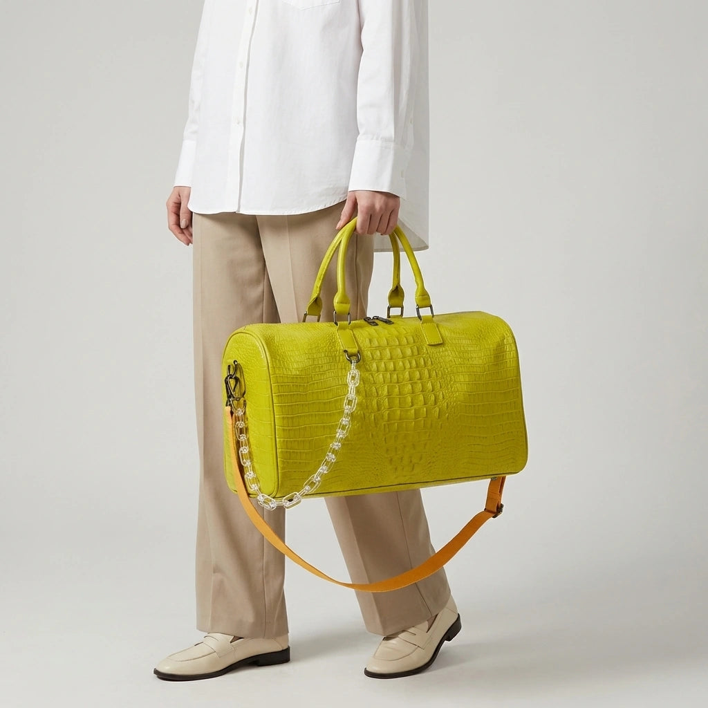 Sac de voyage jaune citron motif croco tenu par les poignées, grande capacité avec chaîne décorative