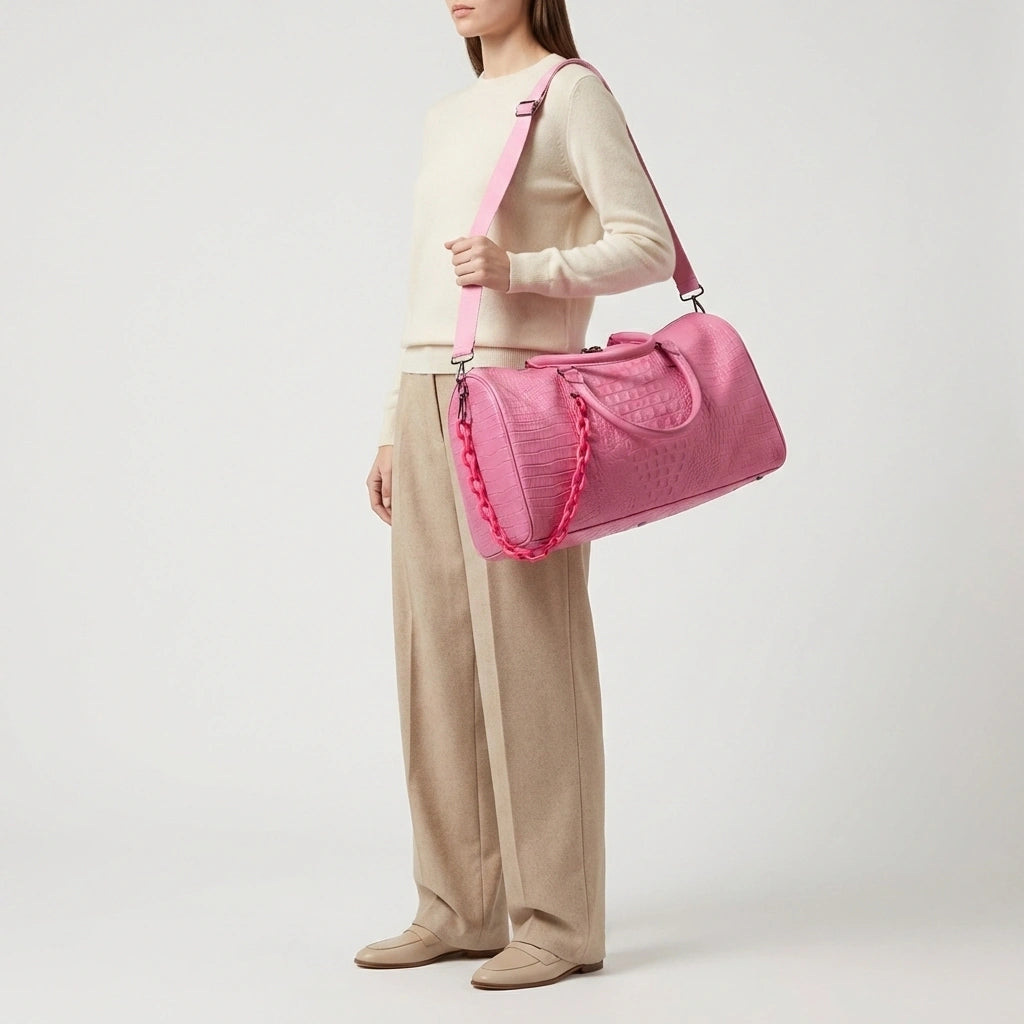 Sac de voyage rose croco porté en bandoulière à l'épaule, look élégant femme de profil, grande taille