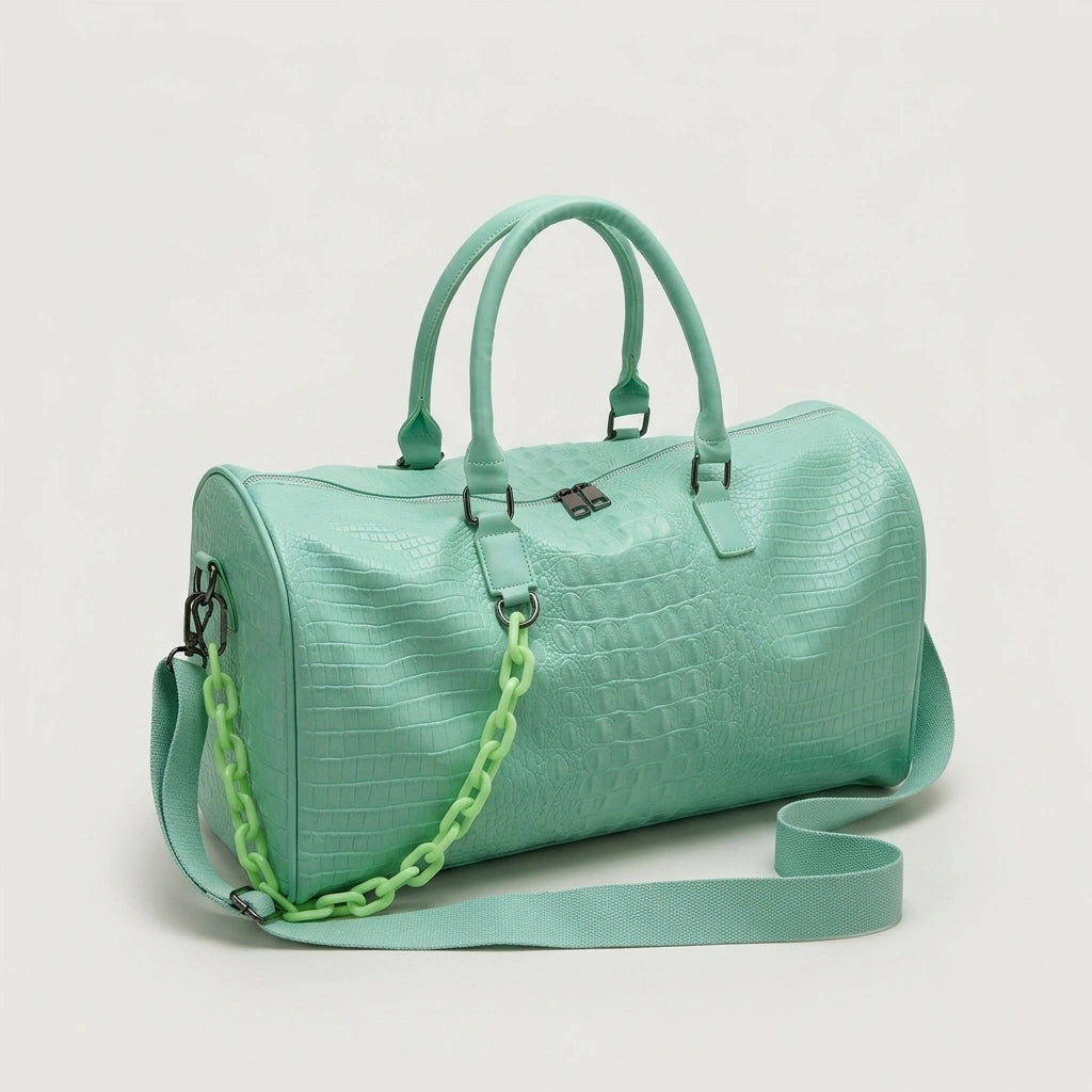 Sac de voyage vert menthe motif croco grande capacité, vue 3/4 sur fond neutre, chaîne décorative