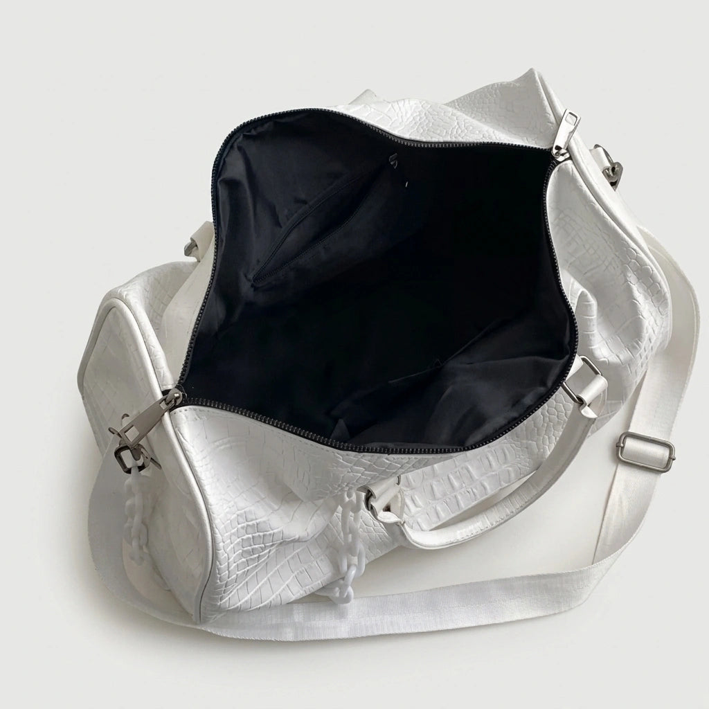 Sac de voyage blanc croco ouvert, révélant l'intérieur noir spacieux, avec bandoulière ajustable