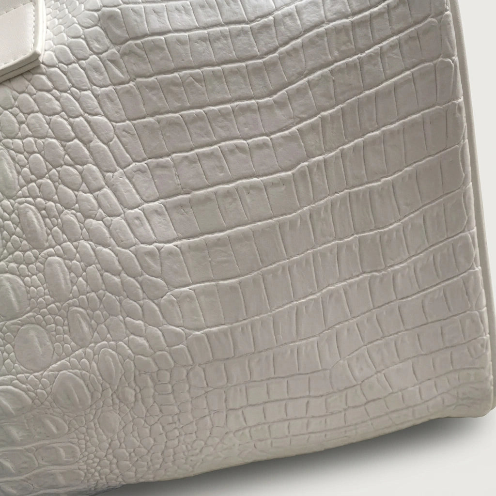 Détail de la texture croco embossée blanc nacré d'un sac de voyage, imperméable et robuste Image