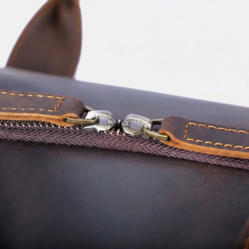 Gros plan sur la fermeture éclair et les coutures d'un sac de voyage en cuir marron vintage de qualité Image
