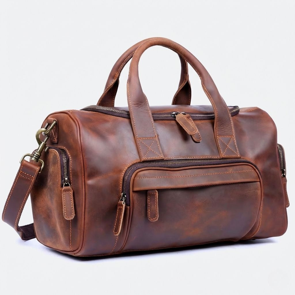 Sac de voyage en cuir véritable marron cognac, vue 3/4, poignées rondes, poche frontale zippée et bandoulière