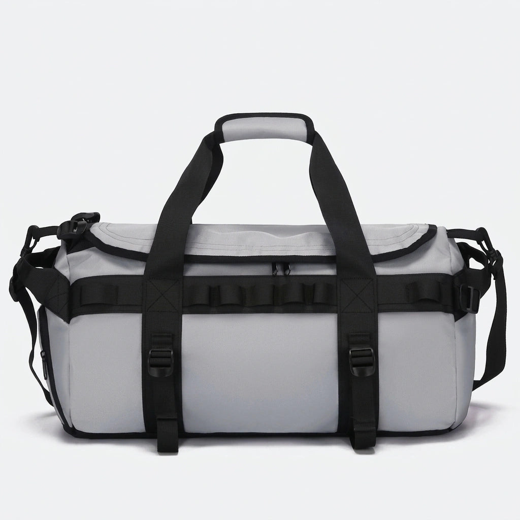Sac de voyage duffle gris clair avec sangles et boucles de compression noires vu de face en studio