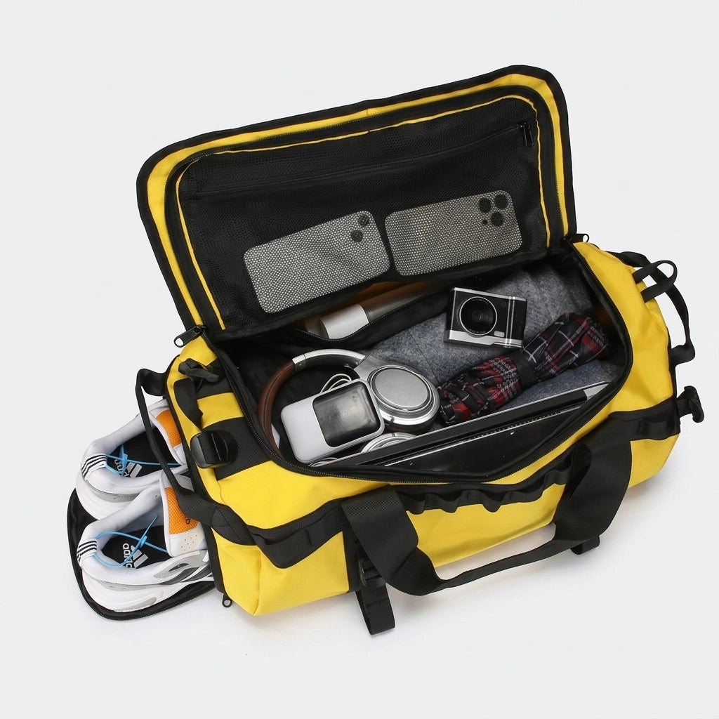 Sac de voyage jaune ouvert montrant le rangement avec chaussures, ordinateur portable, appareil photo et vêtements