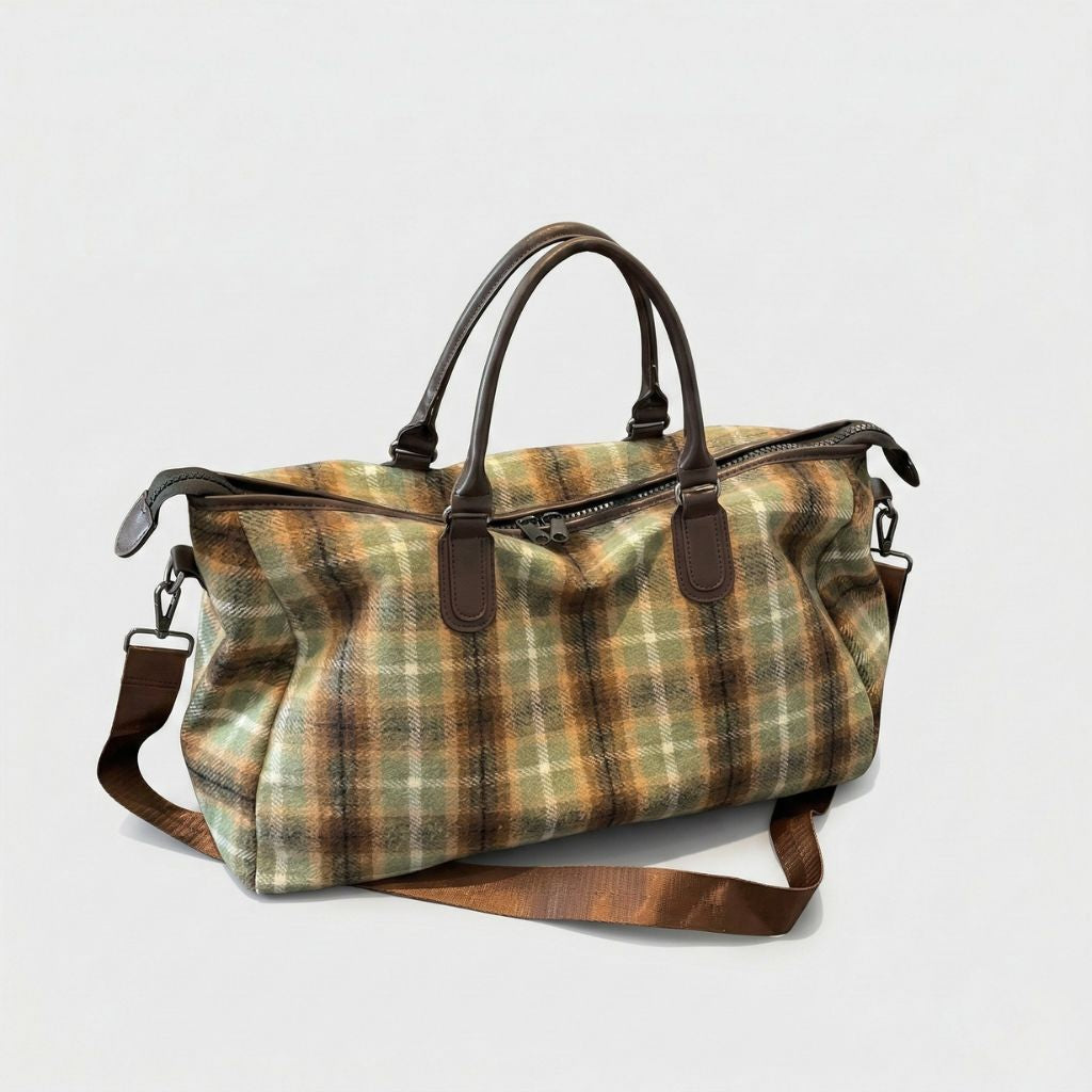 Sac de voyage en toile tartan kaki et ocre, vue 3/4, poignées cuir brun, bandoulière réglable et fermeture zippée