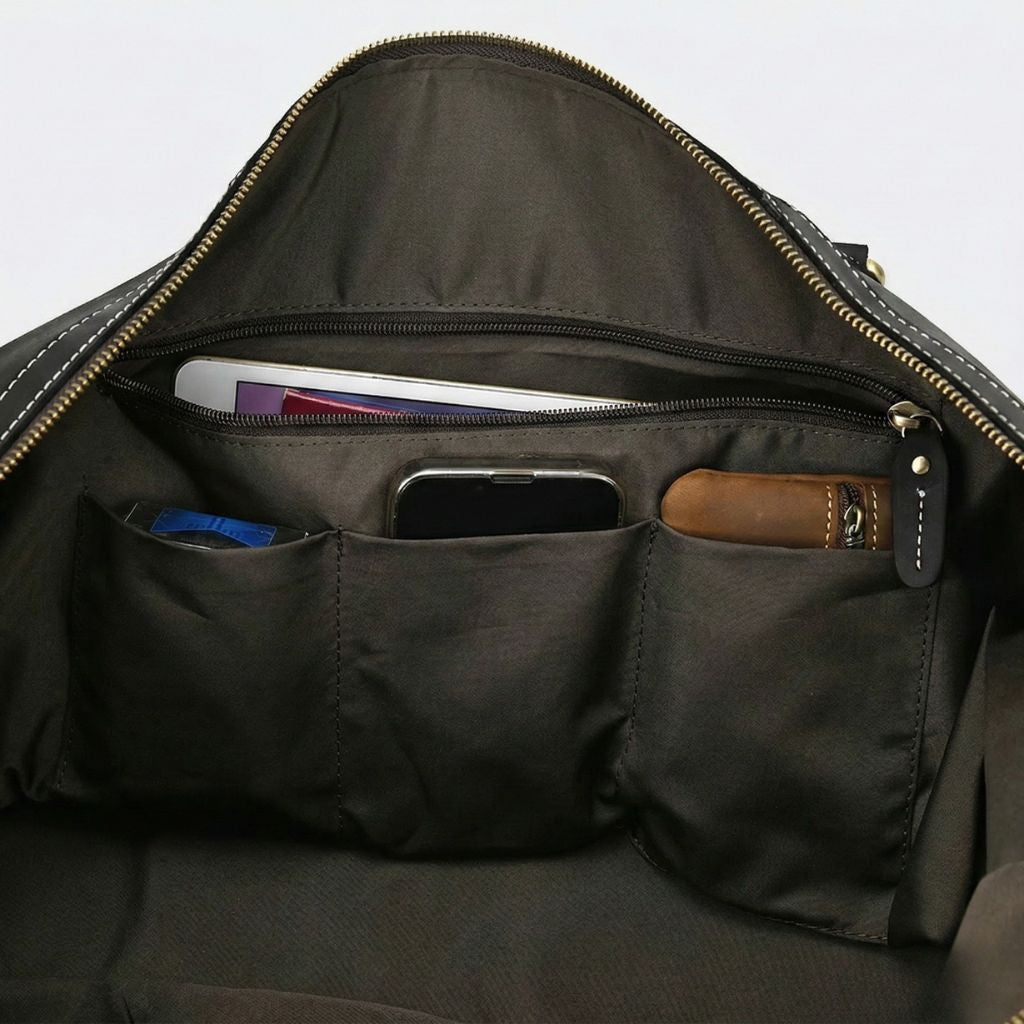 Poches organisées intérieures en nylon noir, trois cases accueillant téléphone, tablette et accessoires