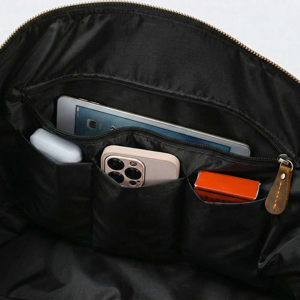 Détail des poches intérieures noires, tablette bleue, smartphone rose et batterie externe dans les cases