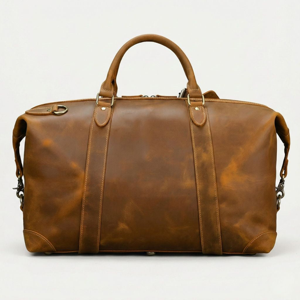 Dos du sac de voyage en cuir vachette cognac huilé, face arrière lisse et anneau en D pour bandoulière
