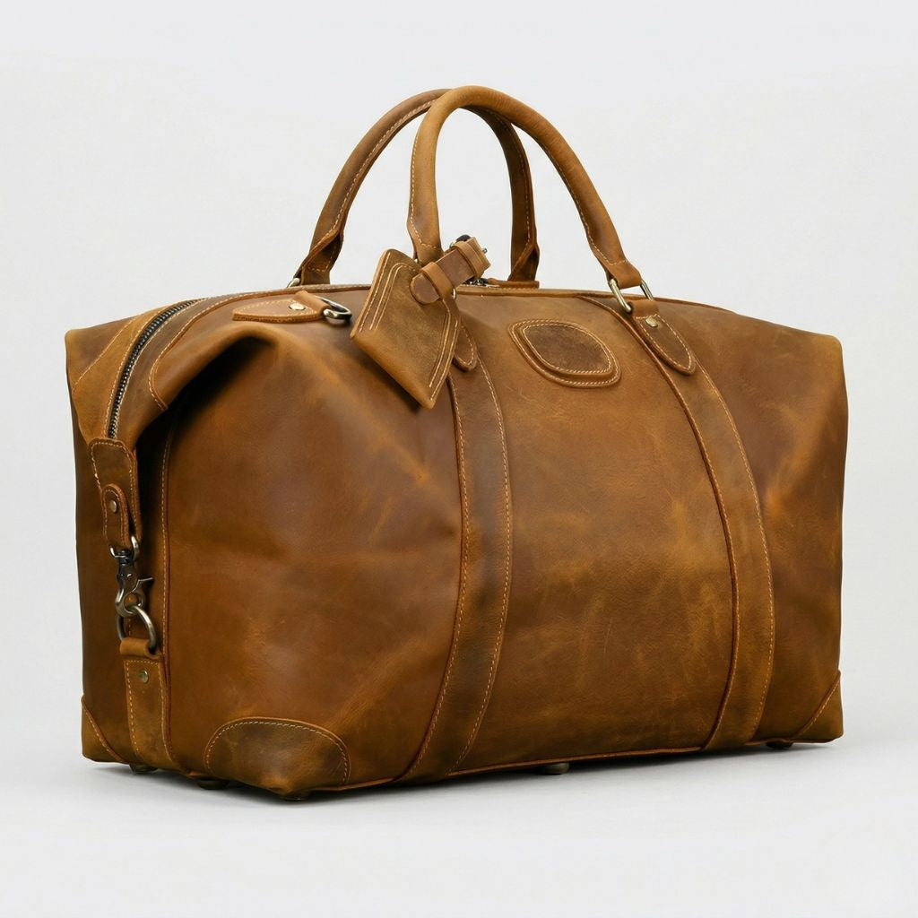 Vue en angle du sac de voyage cuir cognac, tranche avec fermeture zippée et renfort de coin en cuir