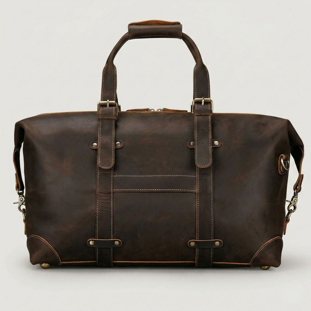 Vue de face du sac cuir marron chocolat, sangles de portage à boucles laiton et poche frontale en cuir souple