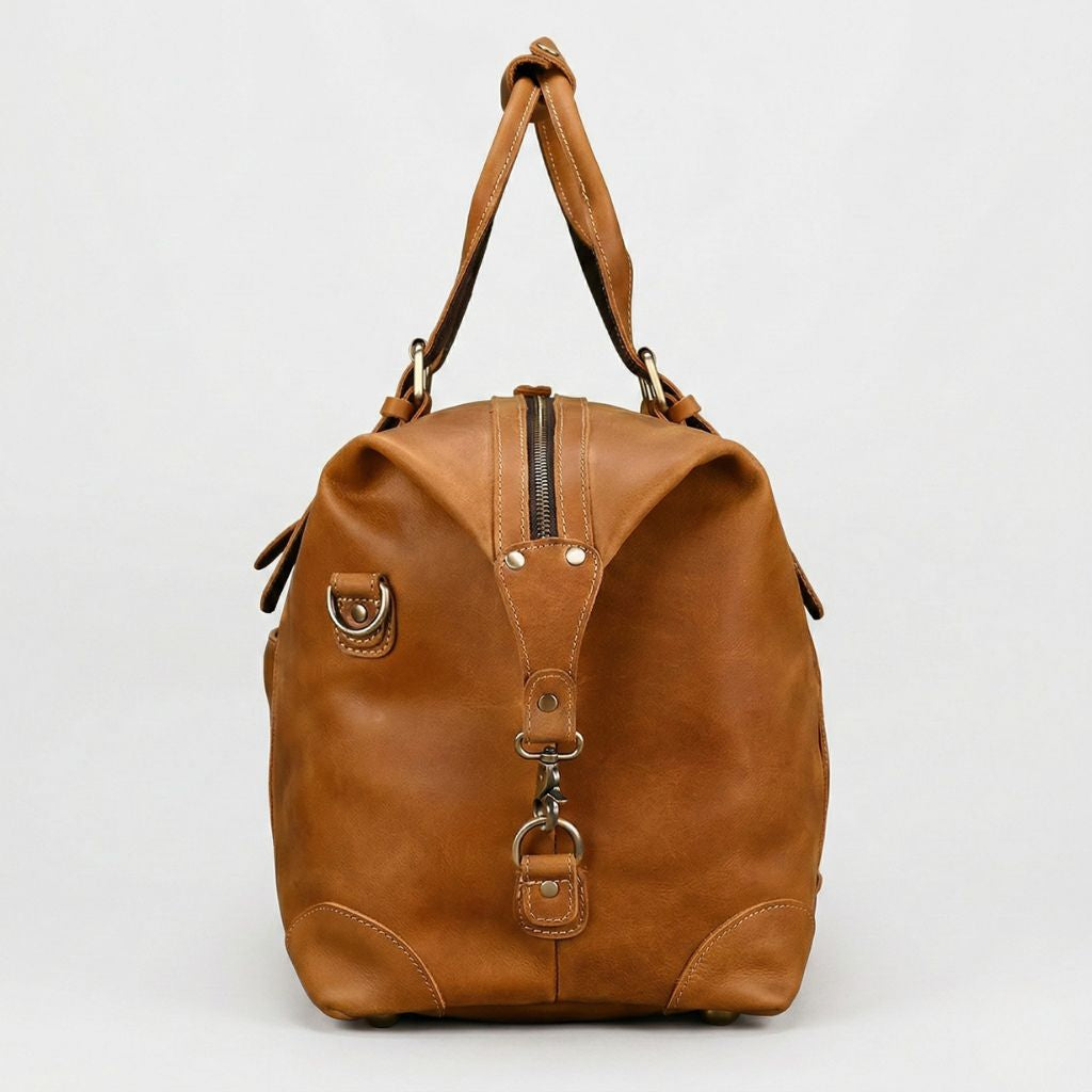 Profil droit du sac de voyage cuir caramel, fermeture zippée sur la tranche et anneau en D en laiton