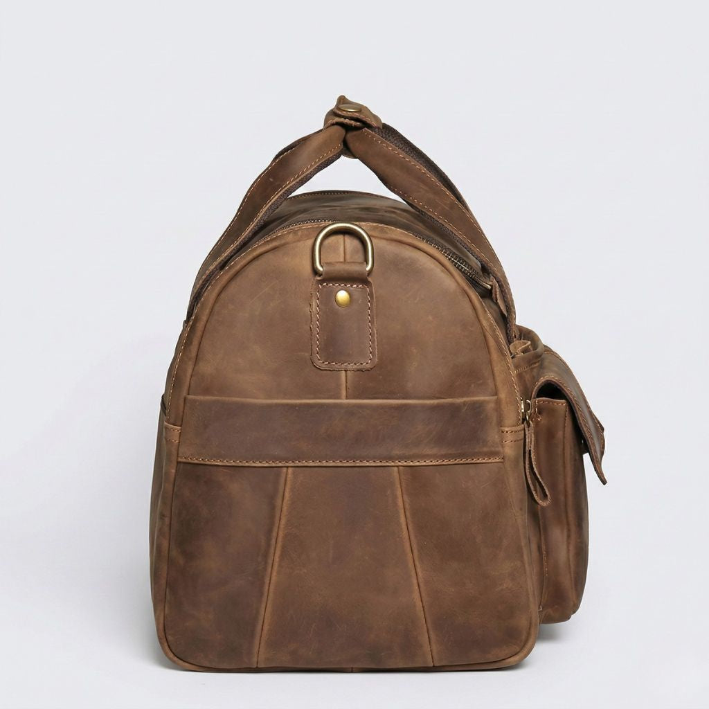 Profil latéral gauche du sac de voyage en cuir Crazy Horse marron, anneau D bronze et fermeture supérieure