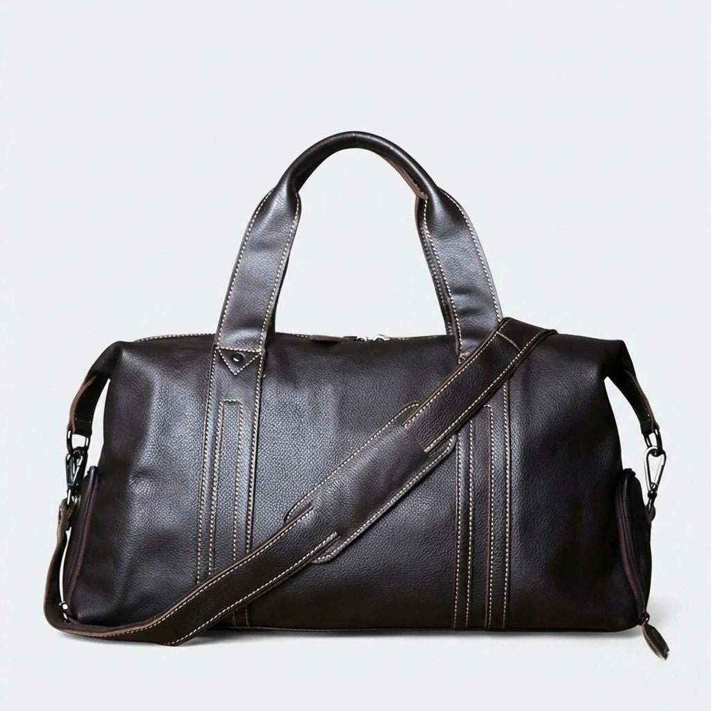 Sac de voyage en cuir grainé marron foncé format cabine, bandoulière réglable et coutures contrastées blanches
